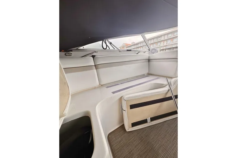 Slide: The Image of 2007 Rinker 270 Express Cruiser interior seating area with white upholstery. - 7