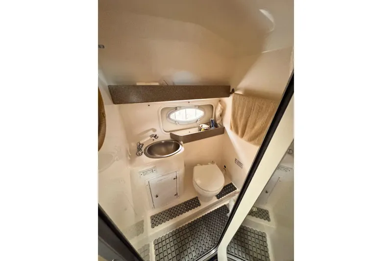 Slide: The Image of 2007 Rinker 270 Express Cruiser bathroom with sink, toilet, and window. - 8