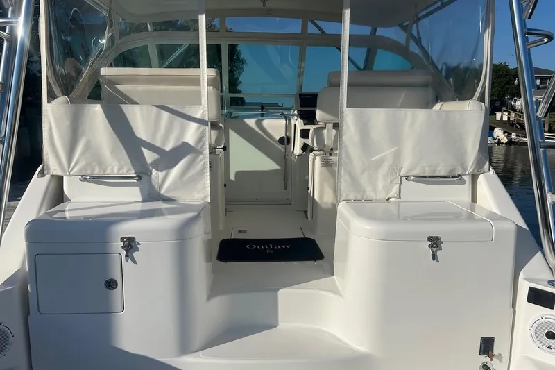 Slide: The Image of 2012 Cabo 32 Express boat interior with white seating and storage compartments. - 12
