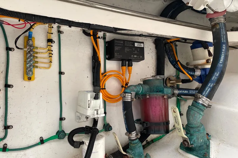 Slide: The Image of Engine compartment of a 2012 Cabo 32 Express boat, showcasing wiring and plumbing components. - 17