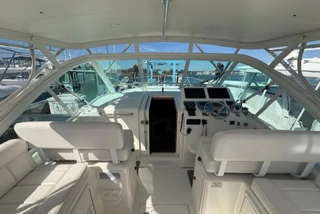 Slide: The Image of Helm of 2012 Cabo 32 Express boat with white seating and modern controls. - 19