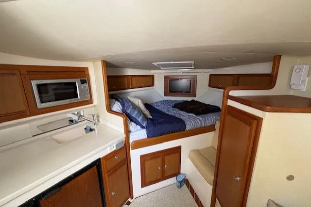 Slide: The Image of Compact kitchen area in a 2012 Cabo 32 Express boat with microwave and sink. - 22