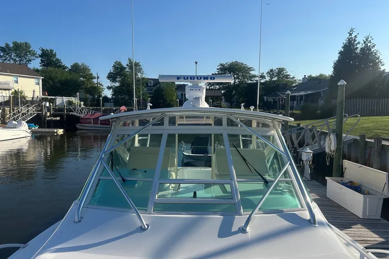 Slide: The Image of 2012 Cabo 32 Express boat docked in a serene marina setting. - 3