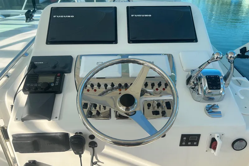 Slide: The Image of Helm of 2012 Cabo 32 Express boat with steering wheel and navigation controls. - 4