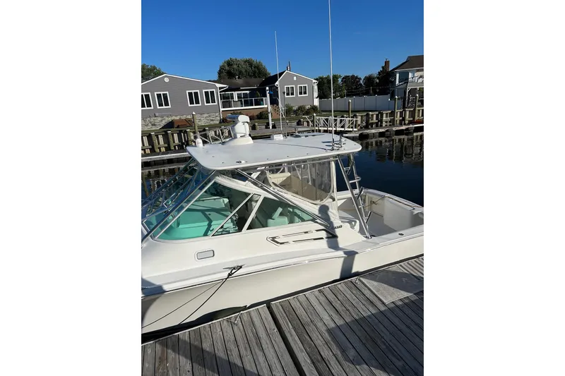 Slide: The Image of 2012 Cabo 32 Express boat docked at marina, clear sky background. - 5
