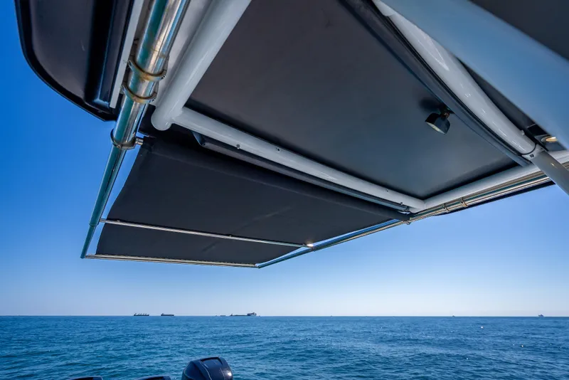 Slide: The Image of 2018 Nor-Tech 390 Sport Center Console boat with sunshade on open sea. - 14