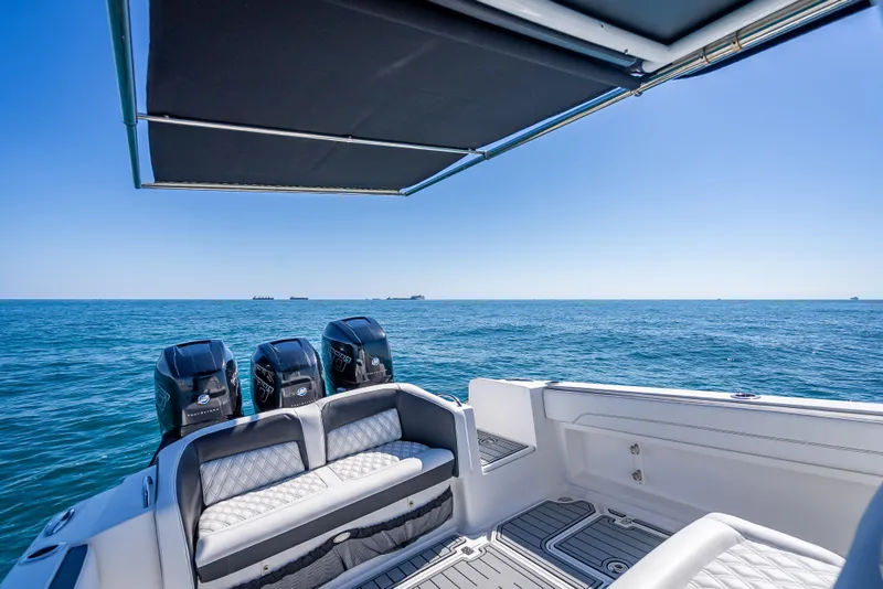 Slide: The Image of 2018 Nor-Tech 390 Sport Center Console boat on open sea with triple engines. - 15