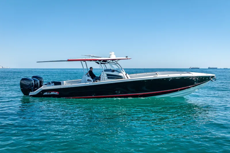 Slide: The Image of 2018 Nor-Tech 390 Sport Center Console boat cruising on clear blue water. - 18