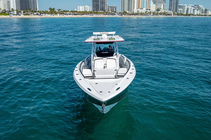 Slide: The Image of 2018 Nor-Tech 390 Sport Center Console boat on clear blue water near city skyline. - 25