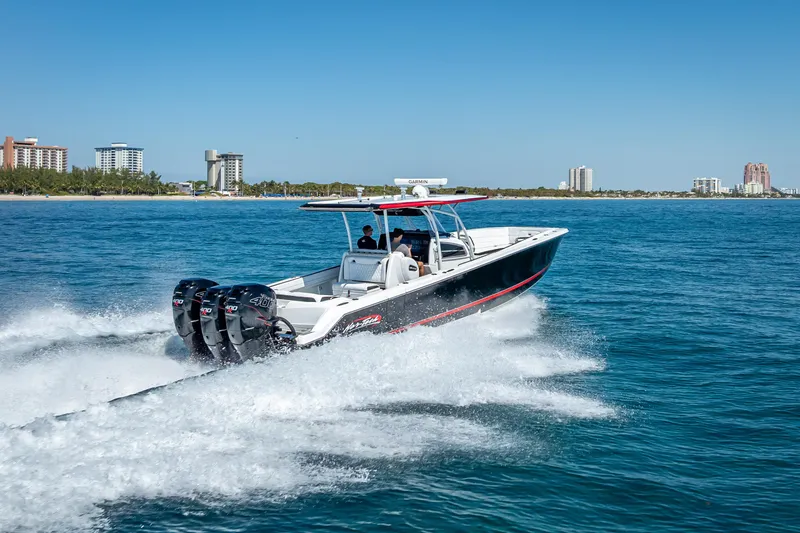 Slide: The Image of 2018 Nor-Tech 390 Sport Center Console cruising on open water near city skyline. - 29