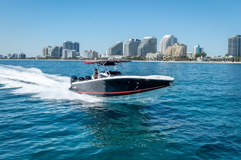 Slide: The Image of 2018 Nor-Tech 390 Sport Center Console cruising near city skyline on clear blue water. - 31