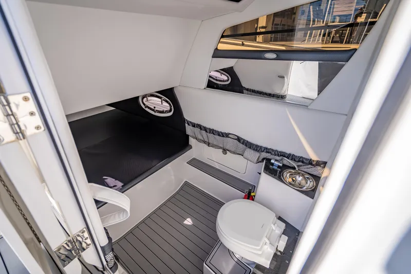 Slide: The Image of Interior cabin of 2018 Nor-Tech 390 Sport Center Console boat, featuring a compact toilet. - 36