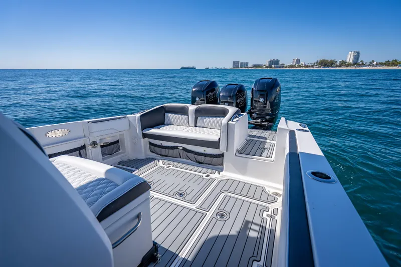 Slide: The Image of 2018 Nor-Tech 390 Sport Center Console boat on open water, featuring spacious seating and triple engines. - 4