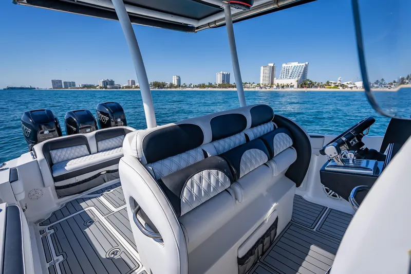 Slide: The Image of 2018 Nor-Tech 390 Sport Center Console boat on water, luxury seating, city skyline in background. - 44