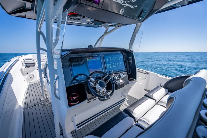 Slide: The Image of 2018 Nor-Tech 390 Sport Center Console boat interior with navigation display on open sea. - 46