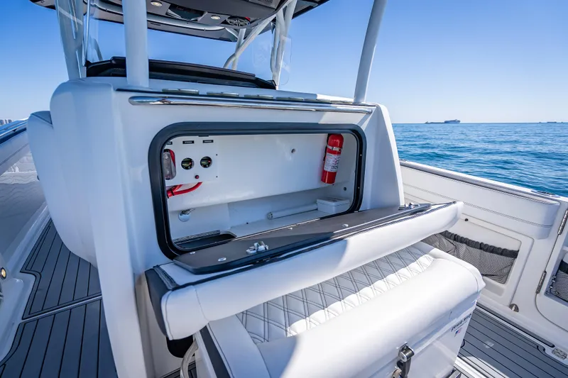 Slide: The Image of 2018 Nor-Tech 390 Sport Center Console boat interior with storage compartment and fire extinguisher. - 9