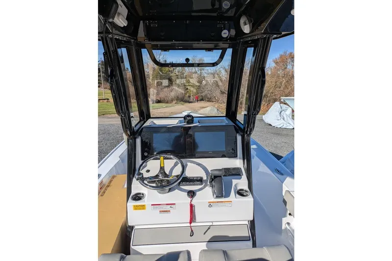 Slide: The Image of 2025 Sportsman Masters 227 Bay Boat dashboard with steering wheel and navigation screens. - 13