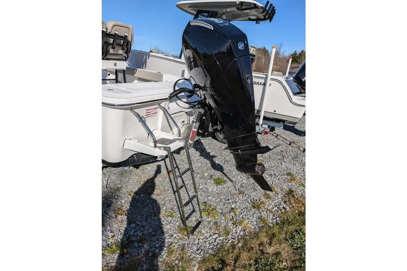 Slide: The Image of 2025 Sportsman Masters 227 Bay Boat with outboard motor and ladder on gravel. - 7