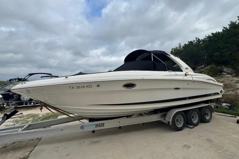 Slide: The Image of 2005 Sea Ray 290 SLX boat on trailer under cloudy sky. - 2
