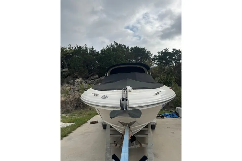 Slide: The Image of 2005 Sea Ray 290 SLX boat on trailer, covered, with cloudy sky background. - 3