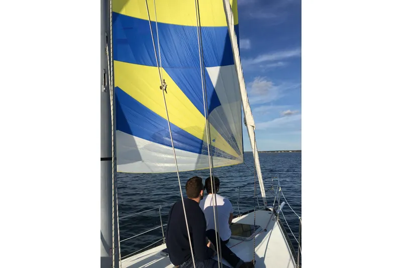 Slide: The Image of Two people sailing on a C&C 110 yacht with colorful sails. - 10