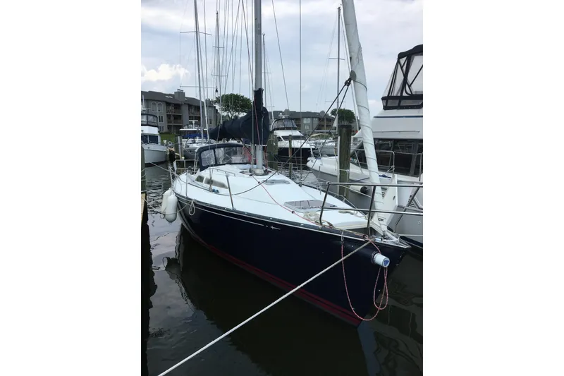 Slide: The Image of Sailboat docked in marina, C&C 110 model, 2001, with white deck and blue hull. - 2