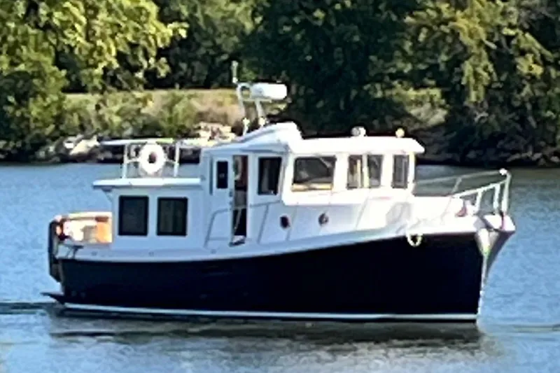 The Image of 2010 American Tug "34" Pilothouse Trawler cruising on a serene river. - 0