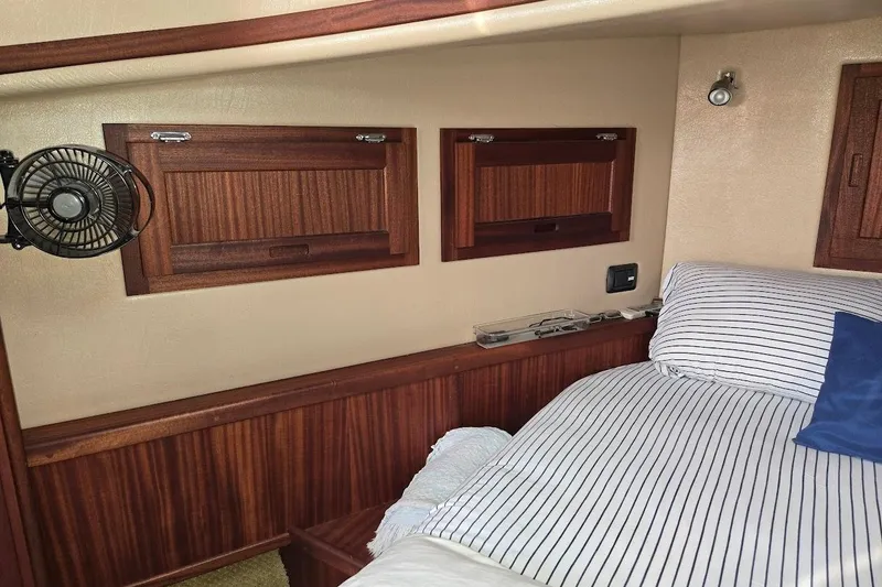 Slide: The Image of Cozy cabin interior of 2010 American Tug "34" Pilothouse Trawler with striped bedding. - 15