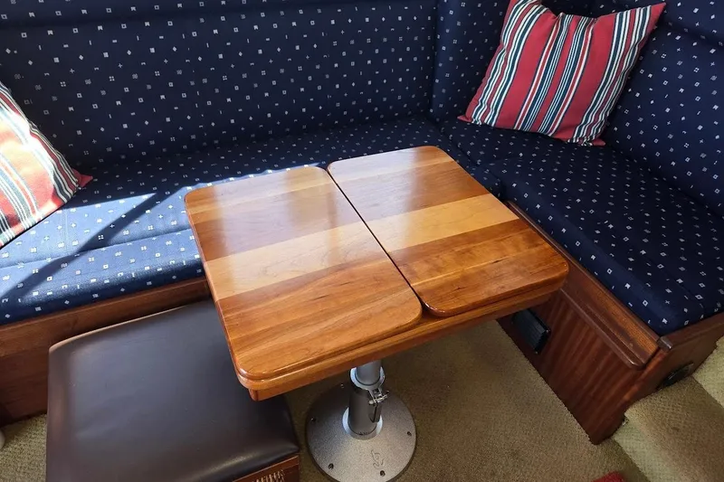 Slide: The Image of Cozy seating area in 2010 American Tug "34" Pilothouse Trawler with wooden table and striped cushions. - 28