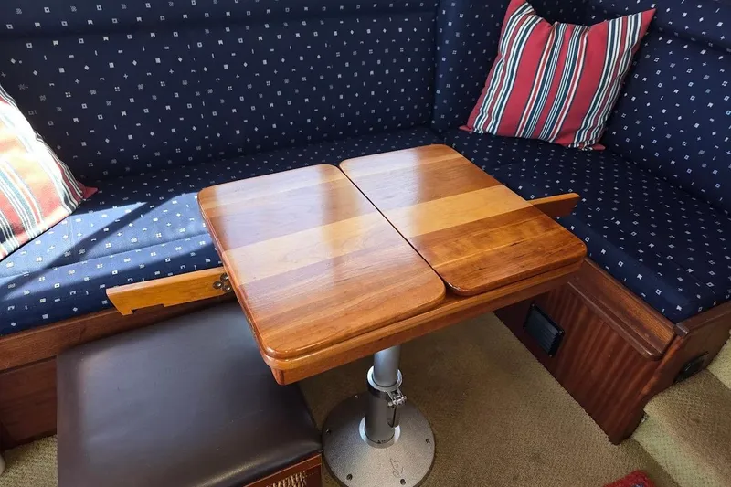 Slide: The Image of Cozy seating area in 2010 American Tug "34" Pilothouse Trawler with wooden table and cushions. - 29
