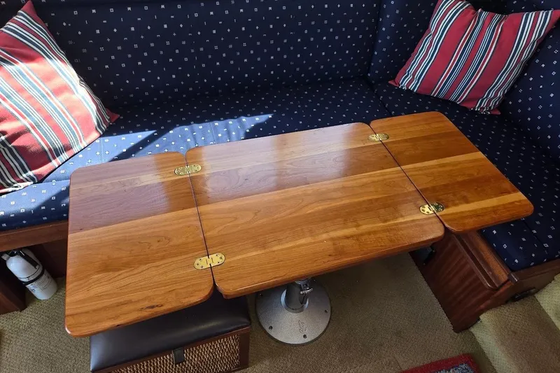 Slide: The Image of Cozy interior of 2010 American Tug "34" Pilothouse Trawler with wooden table and striped cushions. - 30