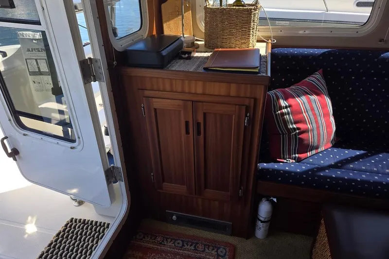 Slide: The Image of Interior of 2010 American Tug "34" Pilothouse Trawler with cozy seating and wooden cabinetry. - 32
