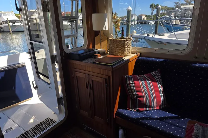 Slide: The Image of Interior of 2010 American Tug "34" Pilothouse Trawler with cozy seating and marina view. - 33