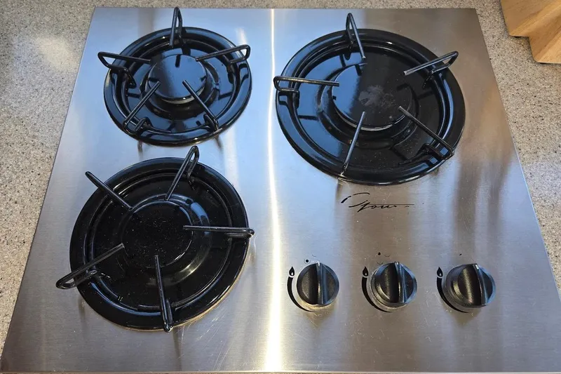 Slide: The Image of Stainless steel stovetop with four burners and control knobs on a countertop. - 40