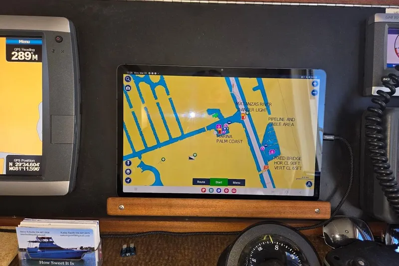 Slide: The Image of Pilothouse navigation equipment on 2010 American Tug "34" Trawler, featuring GPS and marine charts. - 52