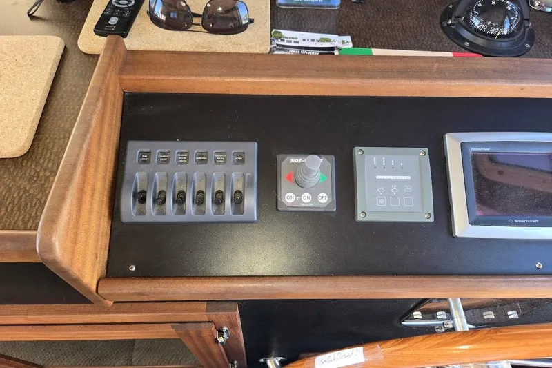 Slide: The Image of Control panel of a 2010 American Tug "34" Pilothouse Trawler with switches and navigation instruments. - 55