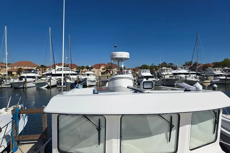 Slide: The Image of 2010 American Tug "34" Pilothouse Trawler docked in a marina under clear blue skies. - 72