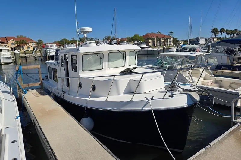 Slide: The Image of 2010 American Tug "34" Pilothouse Trawler docked at marina under clear blue sky. - 74