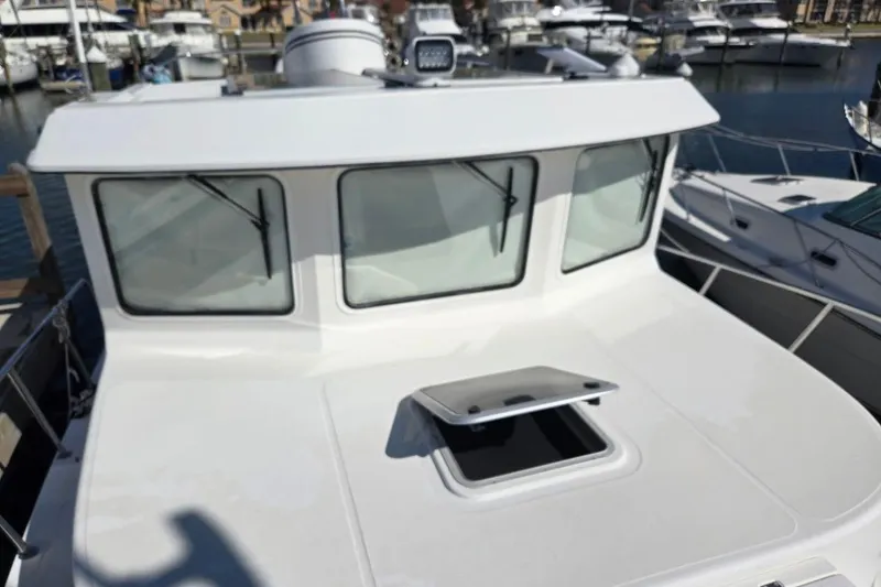 Slide: The Image of 2010 American Tug "34" Pilothouse Trawler docked at marina, showcasing pilothouse windows. - 77