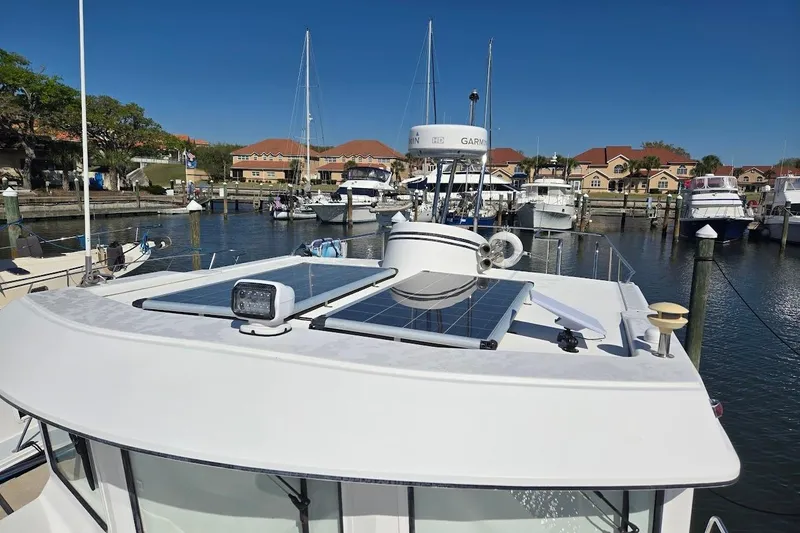 Slide: The Image of 2010 American Tug "34" Pilothouse Trawler docked, featuring solar panels and radar equipment. - 80