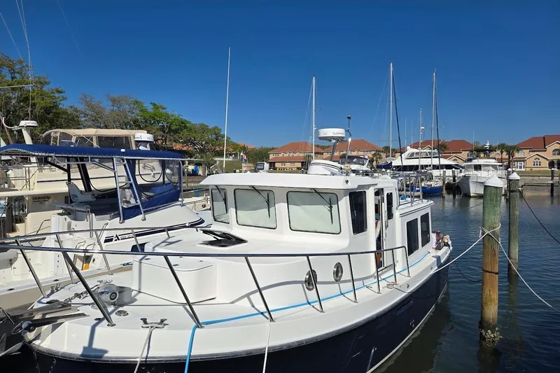 Slide: The Image of 2010 American Tug "34" Pilothouse Trawler docked at marina under clear blue sky. - 91
