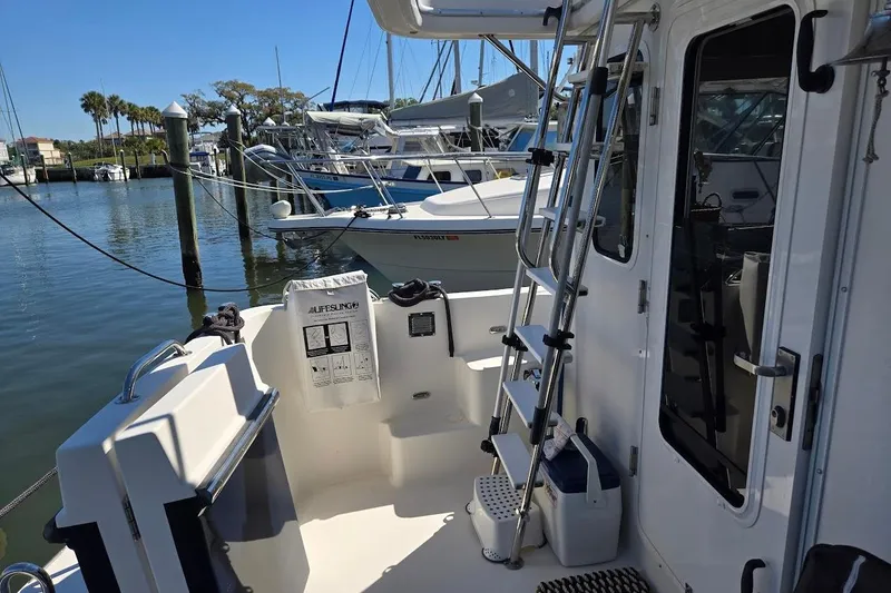 Slide: The Image of 2010 American Tug "34" Pilothouse Trawler docked, featuring exterior ladder and safety equipment. - 92