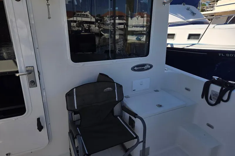 Slide: The Image of 2010 American Tug "34" Pilothouse Trawler deck with chair and window view. - 95