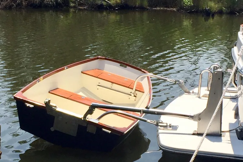 Slide: The Image of Small boat docked beside a 2010 American Tug "34" Pilothouse Trawler on calm water. - 98
