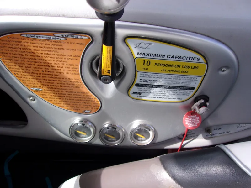 Slide: The Image of 2006 Correct Craft SUPER AIR NAUTIQUE 210 dashboard with capacity and warning labels. - 13