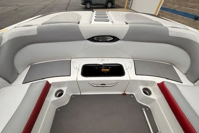 Slide: The Image of 2013 Centurion Enzo SV244 boat interior with gray and red seating, open storage compartment. - 18