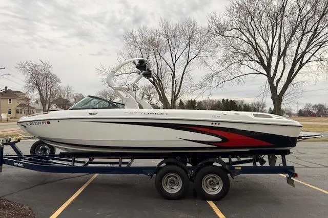 Slide: The Image of 2013 Centurion Enzo SV244 boat on trailer, parked outdoors, overcast sky. - 3