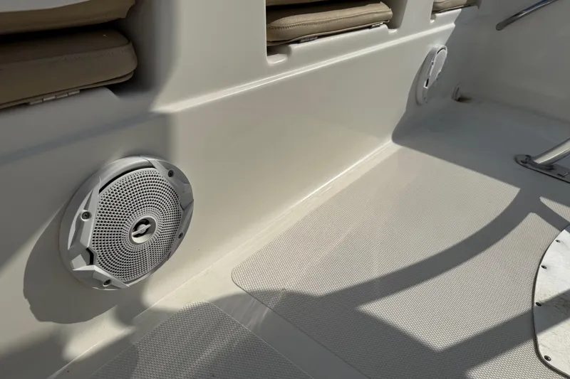 Slide: The Image of 2018 NauticStar 211 Coastal boat interior with speaker and cushioned seating. - 10