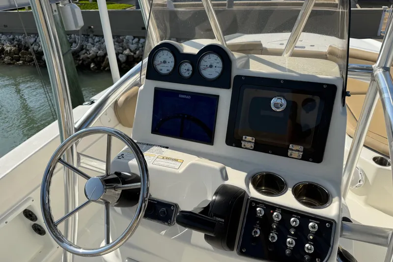 Slide: The Image of 2018 NauticStar 211 Coastal boat dashboard with steering wheel and control panel. - 11