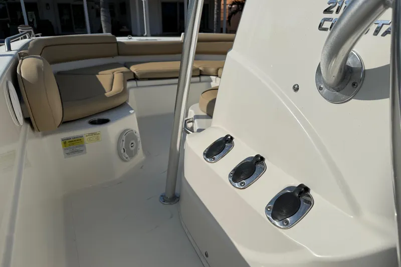 Slide: The Image of 2018 NauticStar 211 Coastal boat interior with beige seating and control panel. - 13